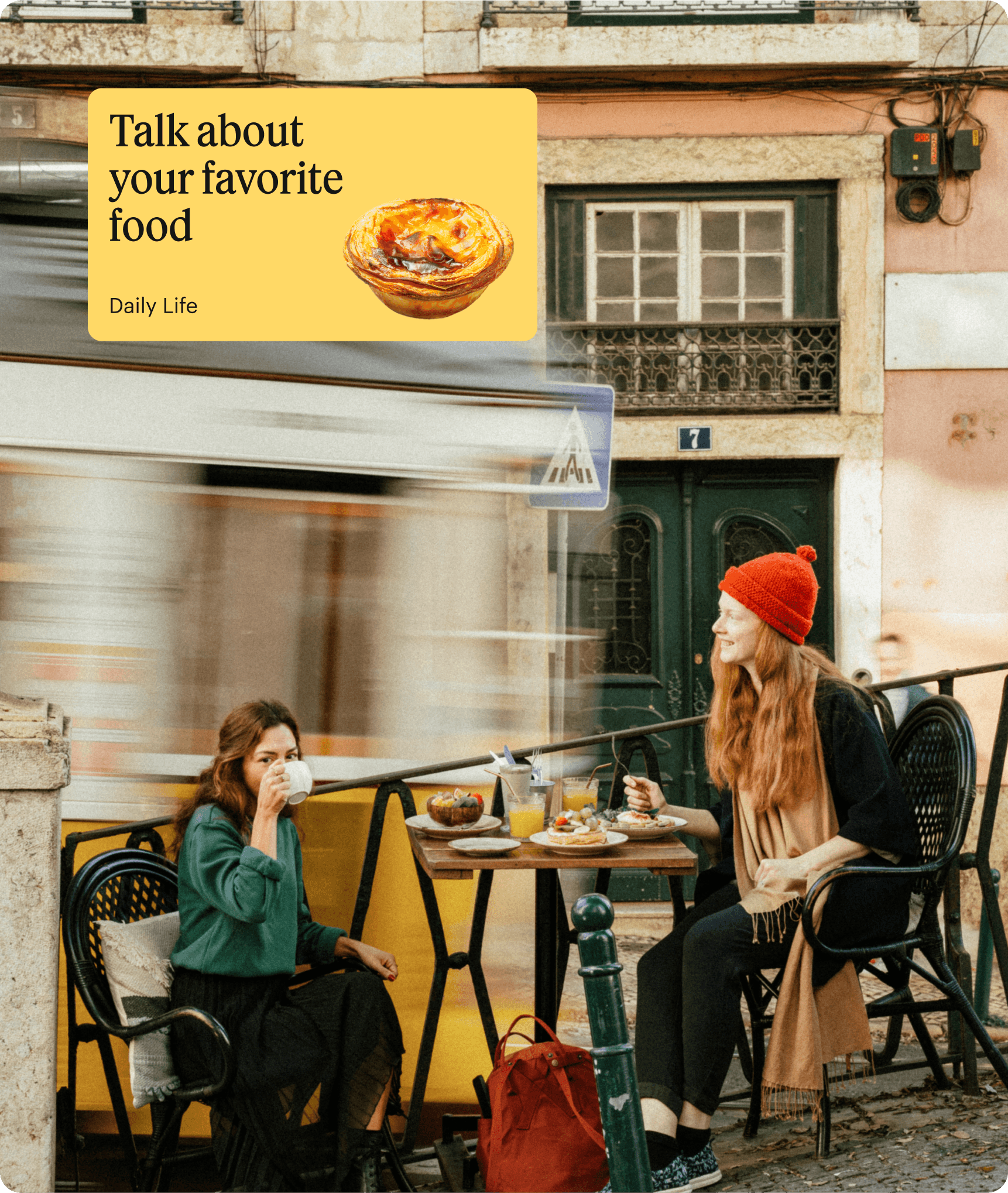 Two girls having breakfast while sitting at a table in the street of a European city.